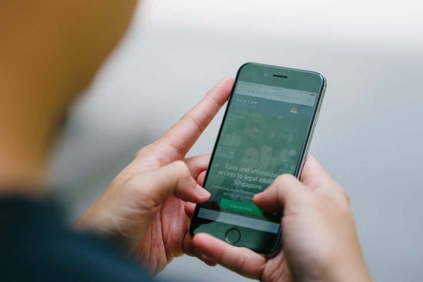 Asia Law Telefon-App, jemand hält das Telefon